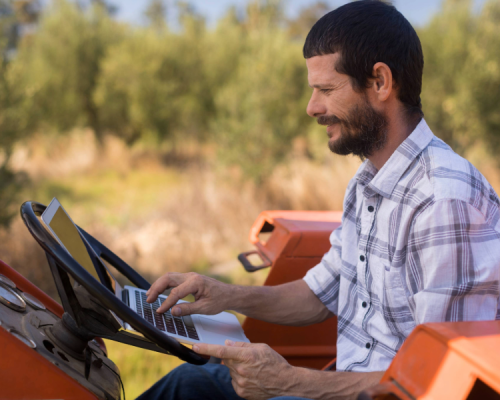 Man using laptop in tractor