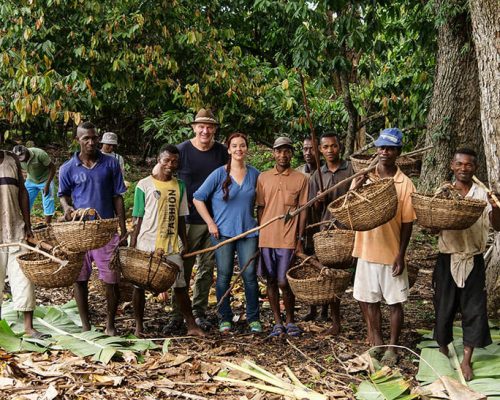 Zotter company at chocolate farm with people holding baskets infront of trees